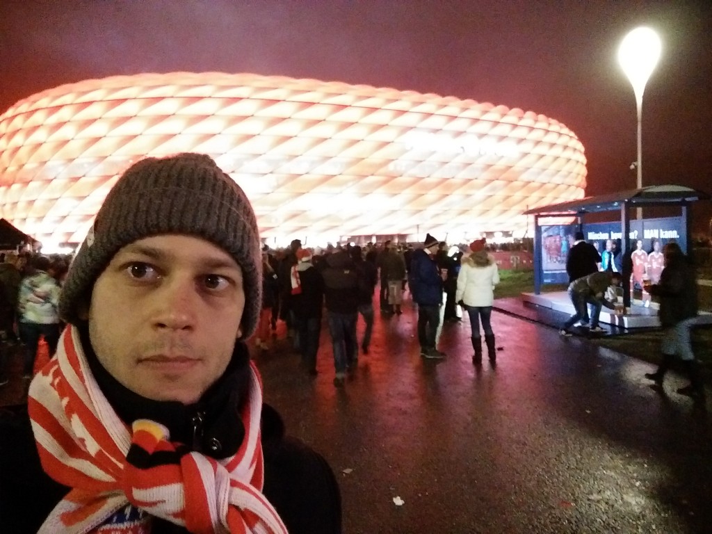 Nem értem, miért van ilyen gülü szemem. Azt hittem, a kamerába néztem, erre most kiderült, hogy nem. Szóval így néz ki az Allianz Arena, ha Bayern-meccs van. Ha az 1860 München játszik, akkor kék.